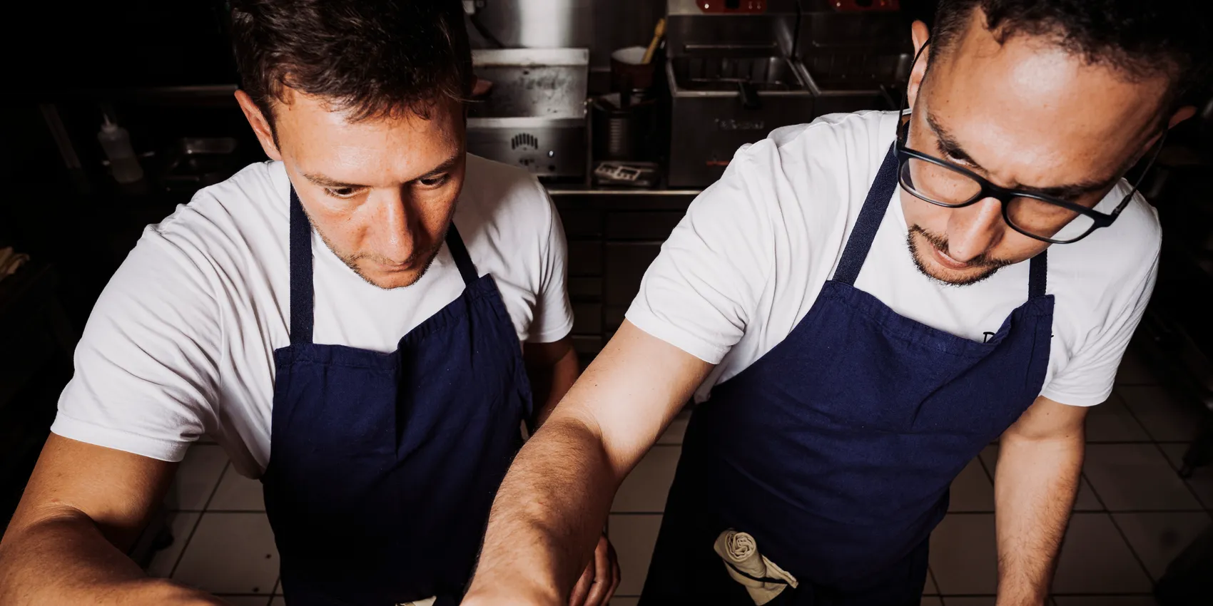Vue en plongée de la cuisine Pipok pendant le service, deux cuisiniers au travail